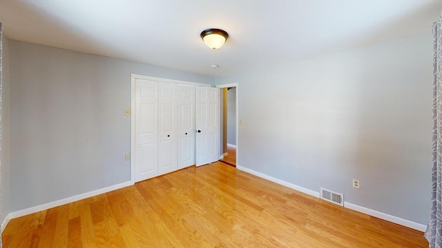 unfurnished bedroom with hardwood / wood-style flooring and a closet