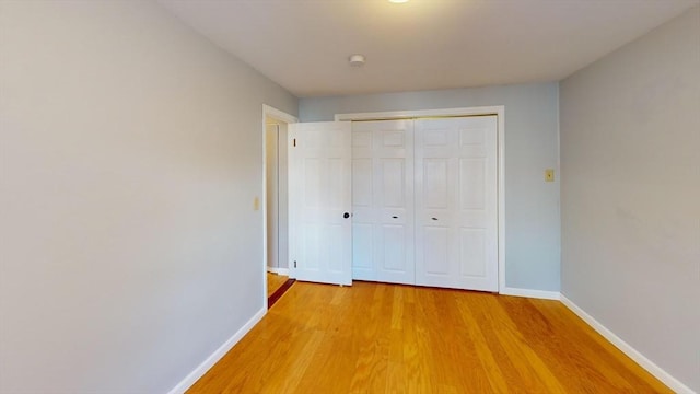 unfurnished bedroom with hardwood / wood-style flooring and a closet