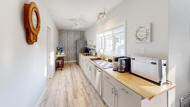 kitchen with white cabinetry, sink, light hardwood / wood-style flooring, and dishwasher