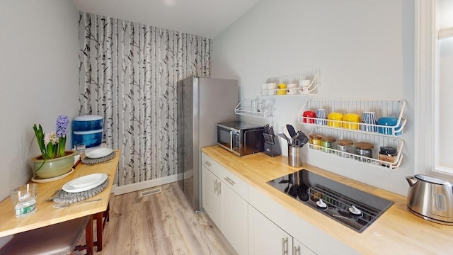 kitchen featuring white cabinetry, light hardwood / wood-style floors, and appliances with stainless steel finishes