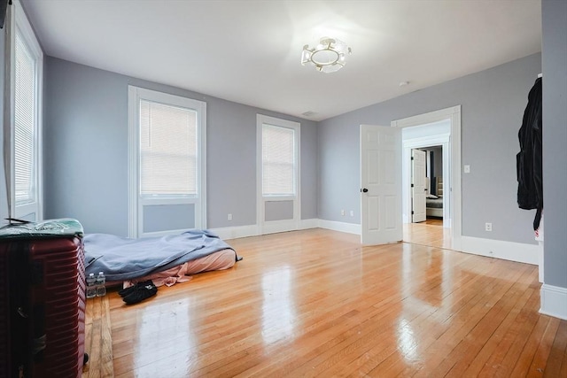 bedroom with light wood finished floors and baseboards