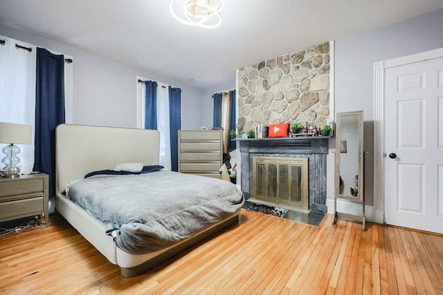 bedroom with a fireplace and hardwood / wood-style flooring