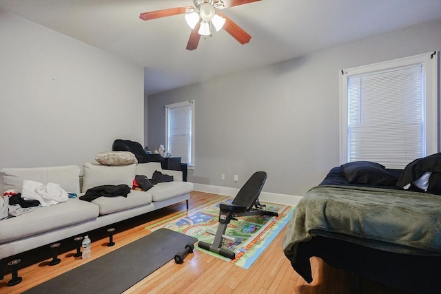 bedroom with ceiling fan, baseboards, and wood-type flooring