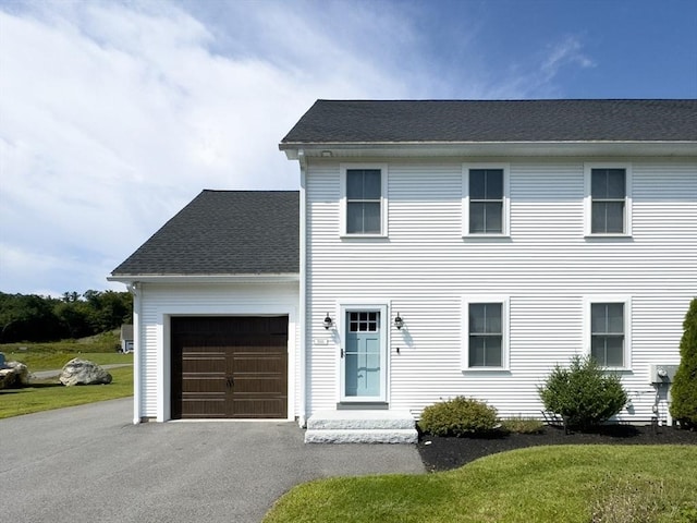 colonial house with a garage and a front lawn