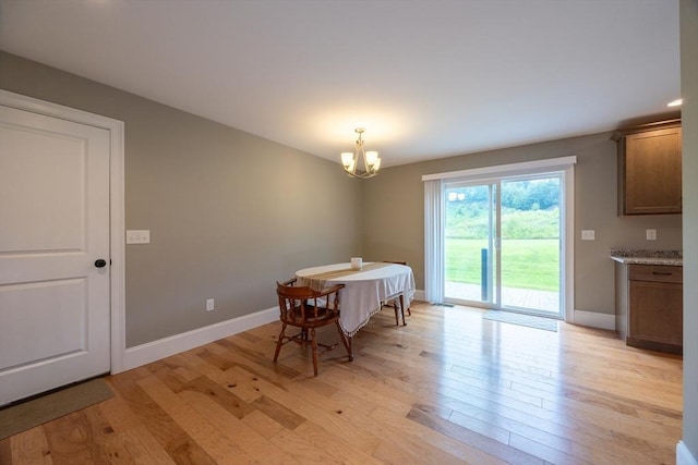 dining area featuring light hardwood / wood-style floors and an inviting chandelier