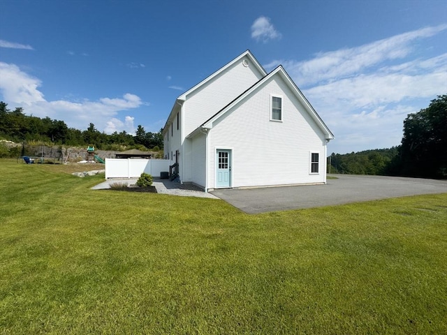 view of side of home with a patio area and a yard