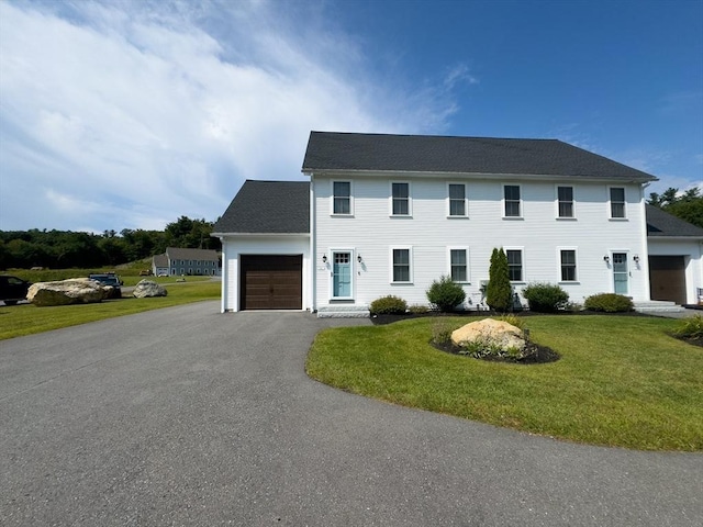 colonial-style house with a garage and a front yard