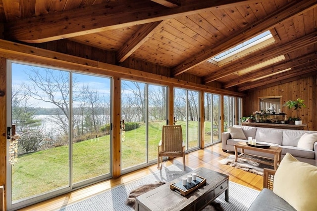 living room featuring a skylight, light wood finished floors, wood walls, plenty of natural light, and wood ceiling