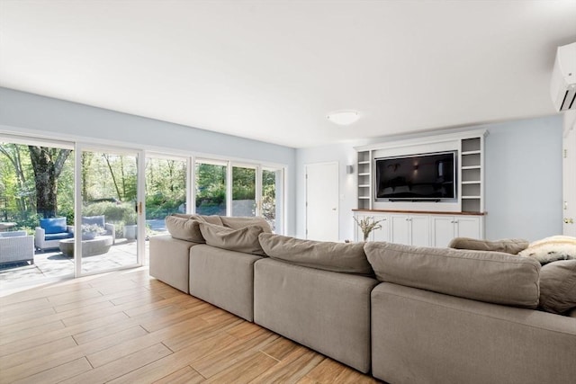 living room with light wood-type flooring and an AC wall unit