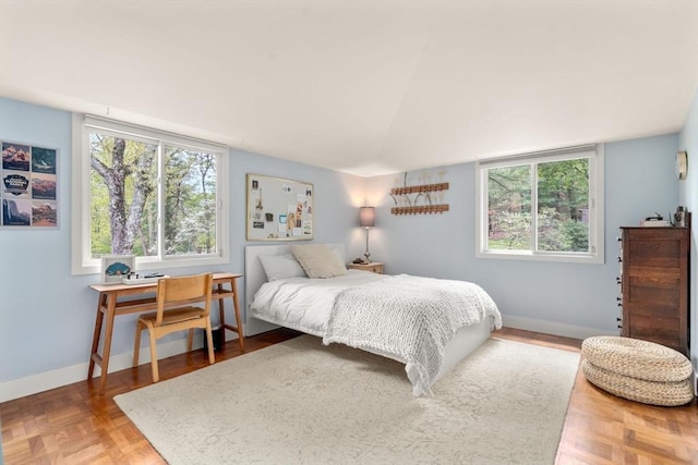 bedroom with baseboards and lofted ceiling