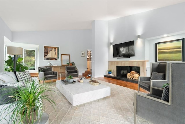 living room featuring a tile fireplace, wood finished floors, lofted ceiling, and recessed lighting