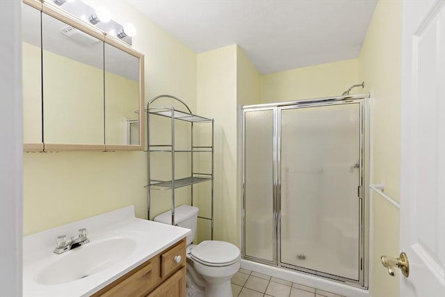full bath featuring a stall shower, vanity, toilet, and tile patterned floors