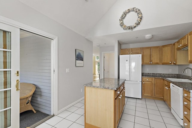 kitchen with light tile patterned floors, white appliances, a sink, and vaulted ceiling