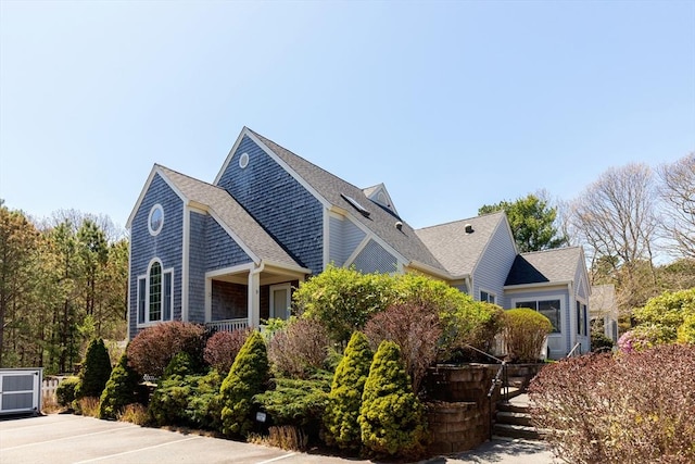 view of side of home featuring roof with shingles