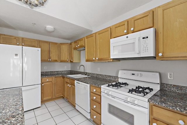 kitchen featuring a sink, white appliances, dark stone countertops, vaulted ceiling, and light tile patterned floors