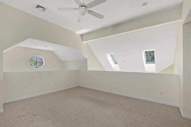 bonus room featuring carpet flooring, baseboards, lofted ceiling with skylight, and visible vents