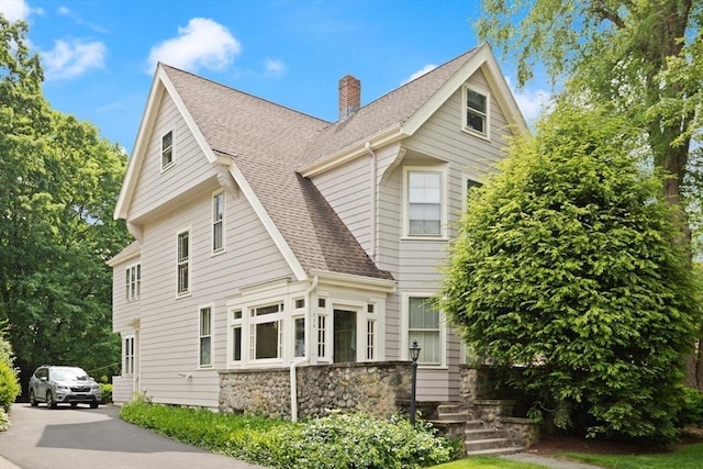 210 Melrose St, Newton, MA 02466 - view of front of property with a shingled roof, a chimney, and stone siding
