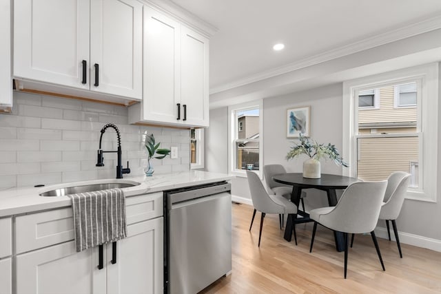 kitchen with stainless steel dishwasher, light hardwood / wood-style floors, light stone counters, and white cabinetry