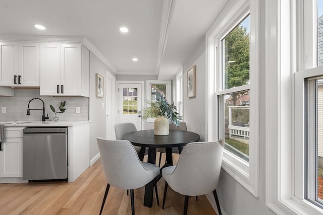 dining space featuring a wealth of natural light, light hardwood / wood-style flooring, and ornamental molding