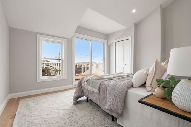 bedroom with access to exterior, a closet, and hardwood / wood-style flooring