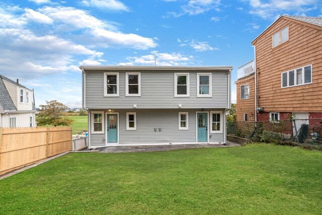 rear view of house with a yard and a patio