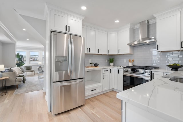 kitchen featuring white cabinetry, stainless steel appliances, wall chimney range hood, and light wood-type flooring