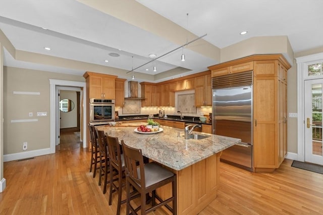 kitchen with stainless steel built in fridge, a sink, baseboards, backsplash, and recessed lighting