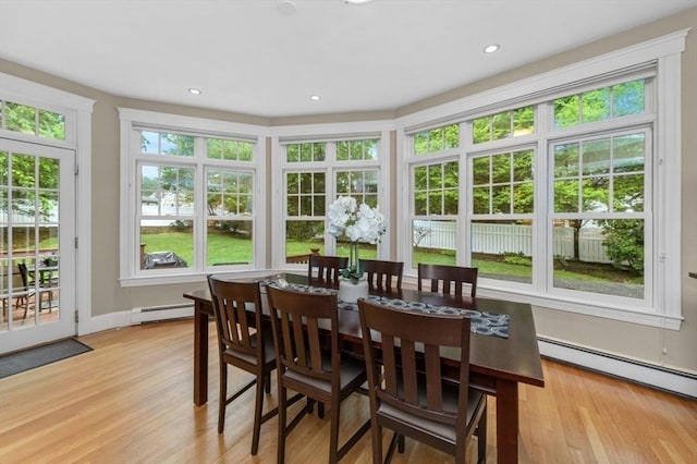 sunroom with a baseboard heating unit, a baseboard radiator, wood finished floors, a deck, and recessed lighting