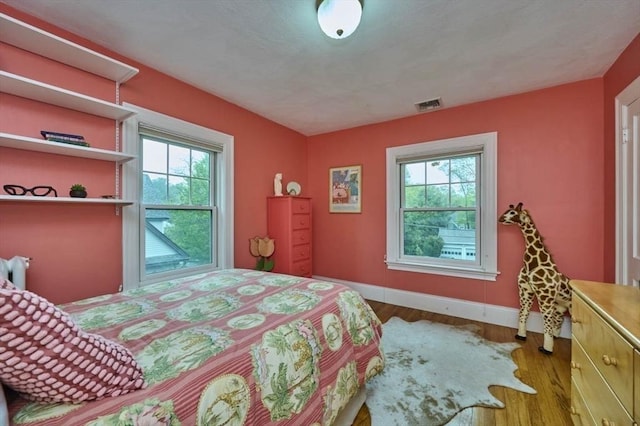 bedroom featuring wood finished floors and baseboards