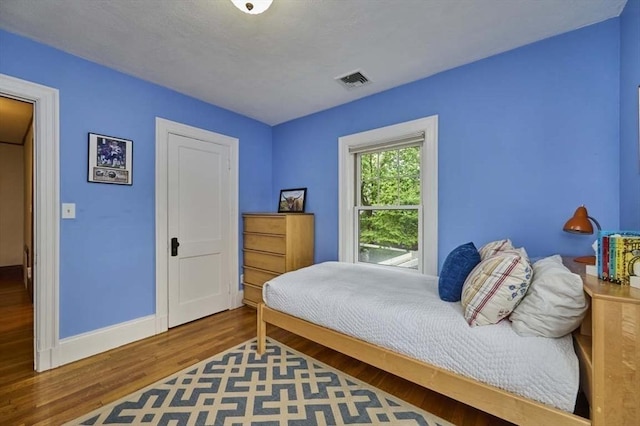 bedroom with wood finished floors and baseboards