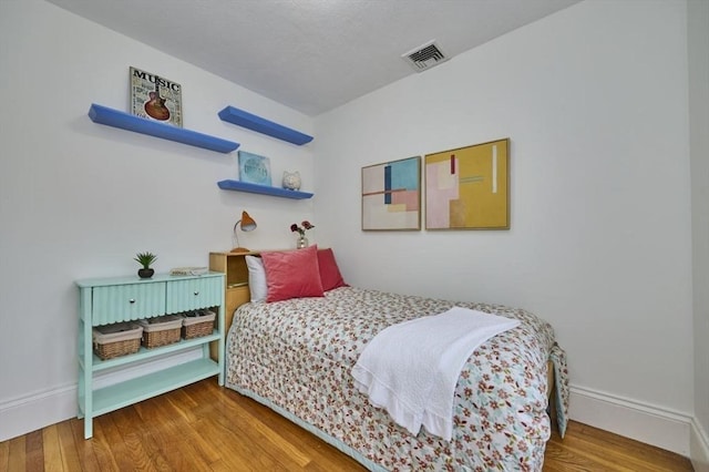 bedroom featuring wood finished floors and baseboards