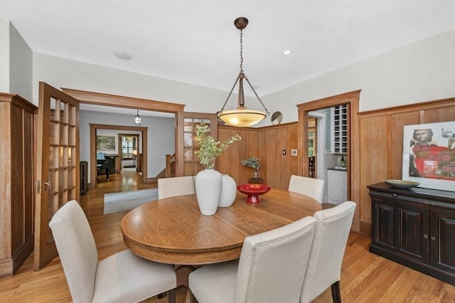 dining area featuring light wood-style flooring and stairs