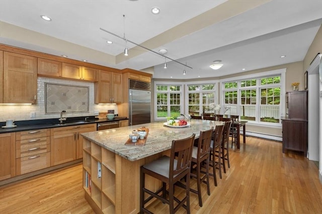 kitchen featuring stainless steel appliances, a sink, healthy amount of natural light, decorative backsplash, and recessed lighting