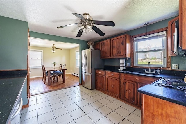 kitchen featuring a sink, appliances with stainless steel finishes, ceiling fan, and dark countertops