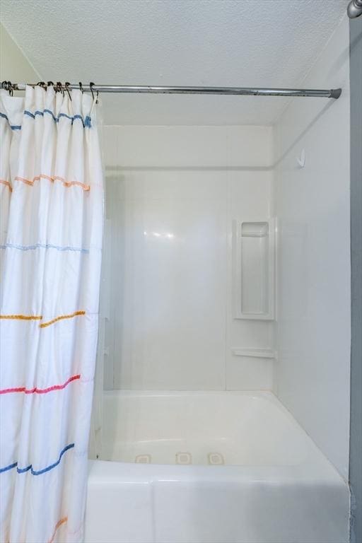 full bath featuring a textured ceiling and shower / tub combo with curtain