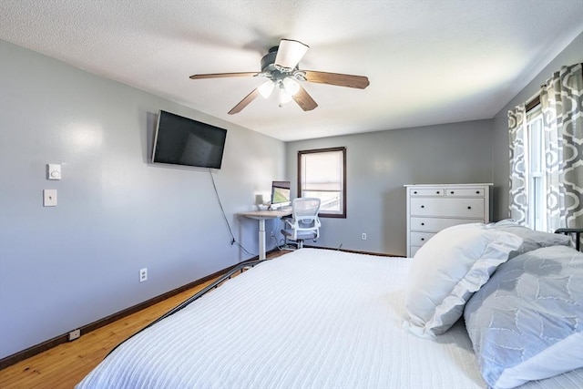 bedroom featuring baseboards, a ceiling fan, and wood finished floors