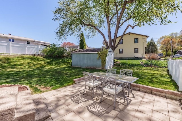 view of patio / terrace featuring an outdoor structure, outdoor dining area, a shed, and a fenced backyard