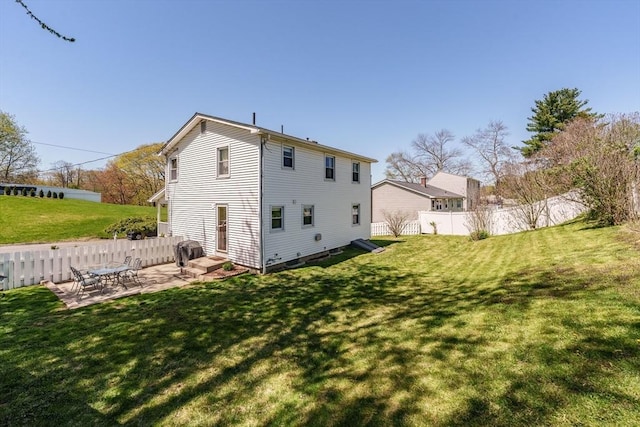 back of property with a lawn, a patio, and fence