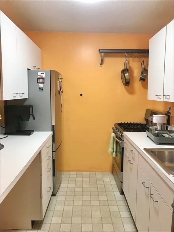 kitchen with white cabinets, sink, and stainless steel range with gas stovetop