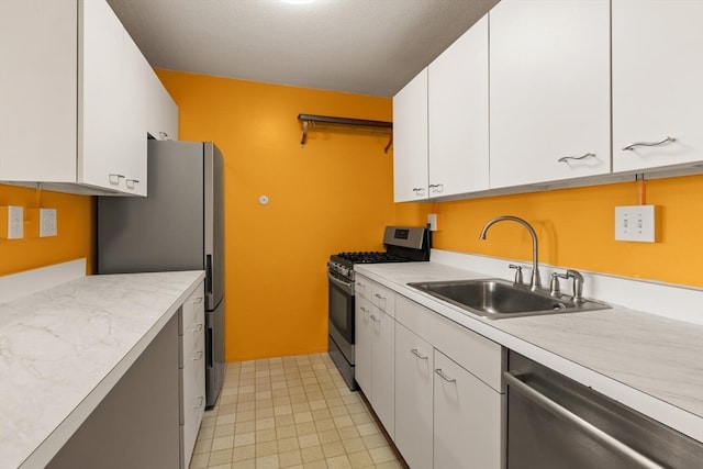 kitchen with appliances with stainless steel finishes, sink, and white cabinets