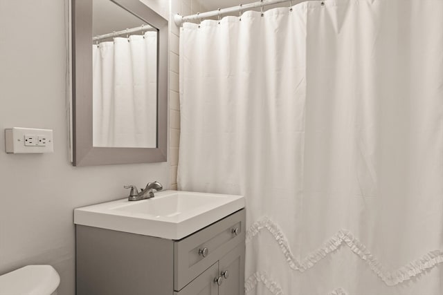 bathroom featuring walk in shower, vanity, and toilet