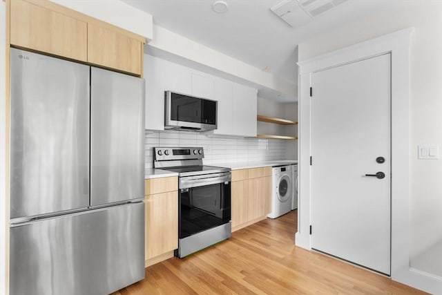 kitchen featuring light brown cabinetry, tasteful backsplash, washer / clothes dryer, light hardwood / wood-style floors, and stainless steel appliances