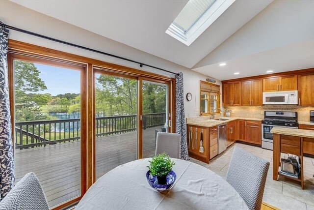 51 Wianno Cir, Barnstable, MA 02655 - kitchen with appliances with stainless steel finishes, a sink, lofted ceiling, a skylight, and decorative backsplash