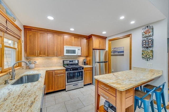 51 Wianno Cir, Barnstable, MA 02655 - kitchen featuring appliances with stainless steel finishes, a sink, decorative backsplash, light stone counters, and recessed lighting
