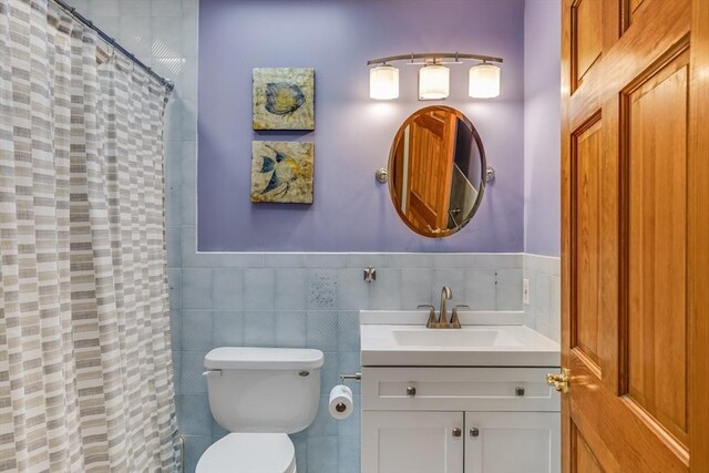 51 Wianno Cir, Barnstable, MA 02655 - full bath with vanity, a shower with shower curtain, toilet, tile walls, and a wainscoted wall