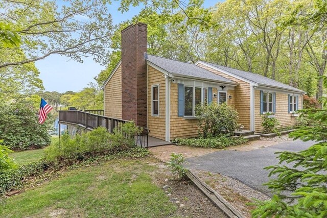 51 Wianno Cir, Barnstable, MA 02655 - view of front facade with a chimney, roof with shingles, and a deck