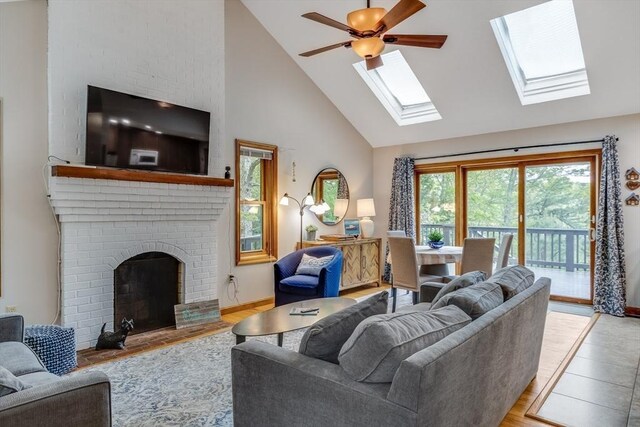 51 Wianno Cir, Barnstable, MA 02655 - living room featuring high vaulted ceiling, wood finished floors, ceiling fan, a fireplace, and a skylight