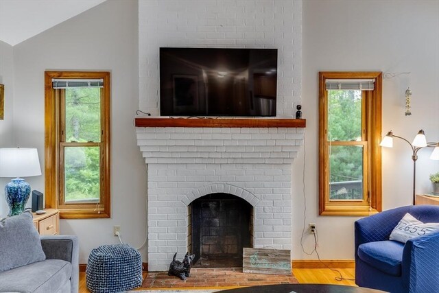 51 Wianno Cir, Barnstable, MA 02655 - living area featuring wood finished floors, plenty of natural light, lofted ceiling, and a brick fireplace