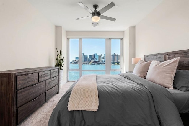 bedroom with light carpet, access to exterior, a view of city, a water view, and visible vents