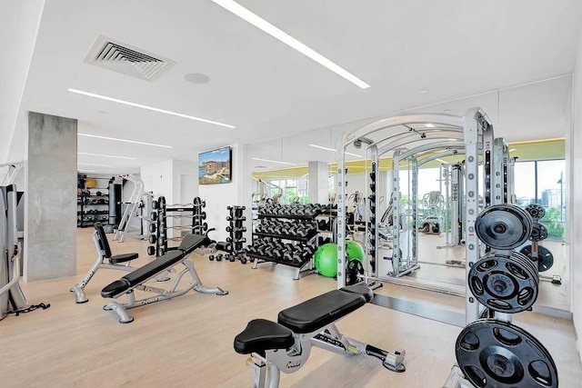 exercise room featuring wood finished floors and visible vents
